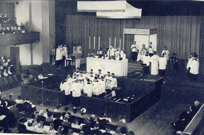 Missa Solene Coram Episcopo celebrada (verus populum) durante a Oitava Semana Litúrgica Nacional em Portland,1947. O Arcebispo E.D. Howard está no trono; à sua direita, o Reverendíssimo Joseph Gilmore, Bispo de Helena; à sua esquerda está o Reverendíssimo Francis Carroll, Bispo de Calgary.